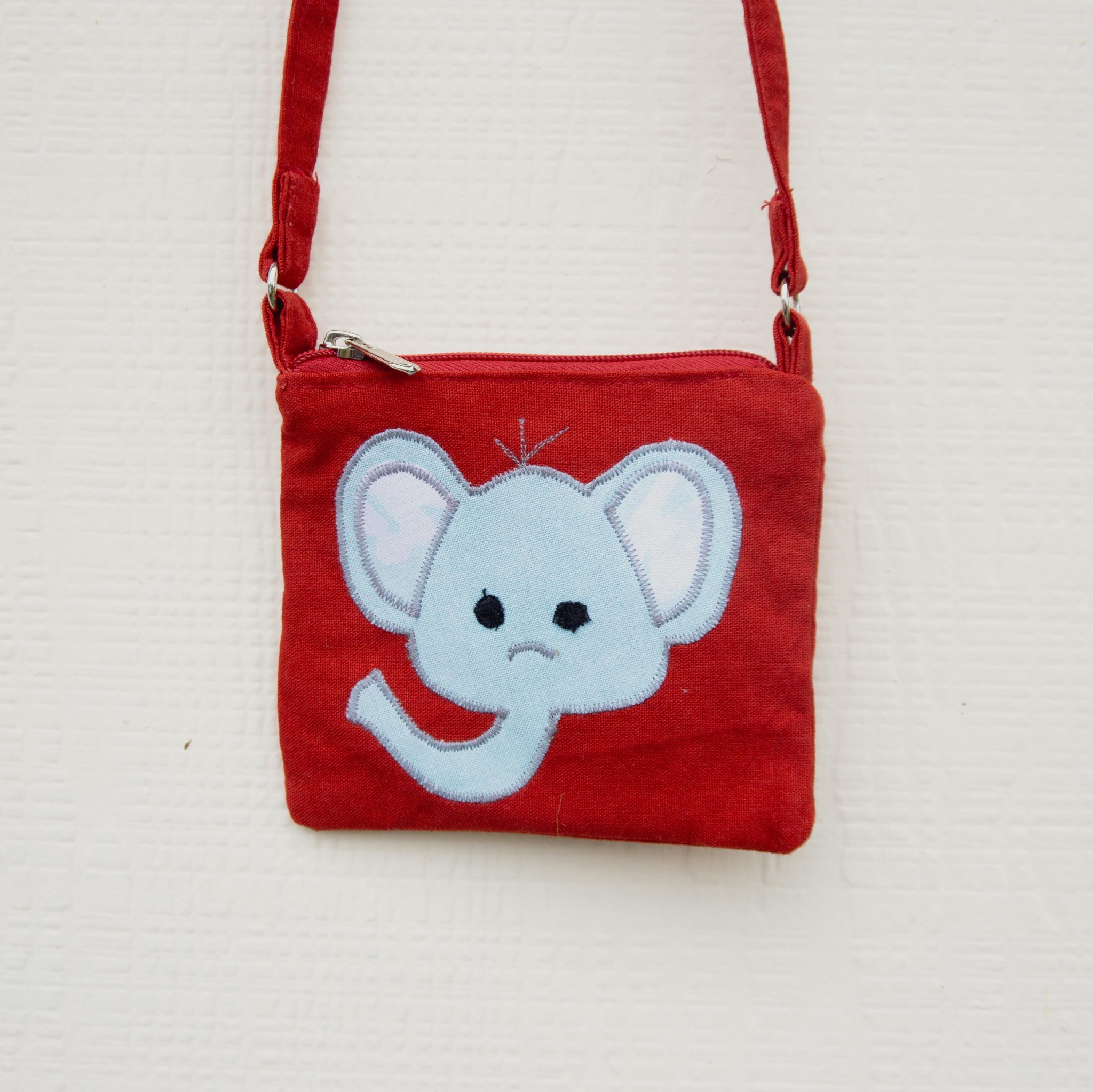 Red bag with a blue elephant design on a white background