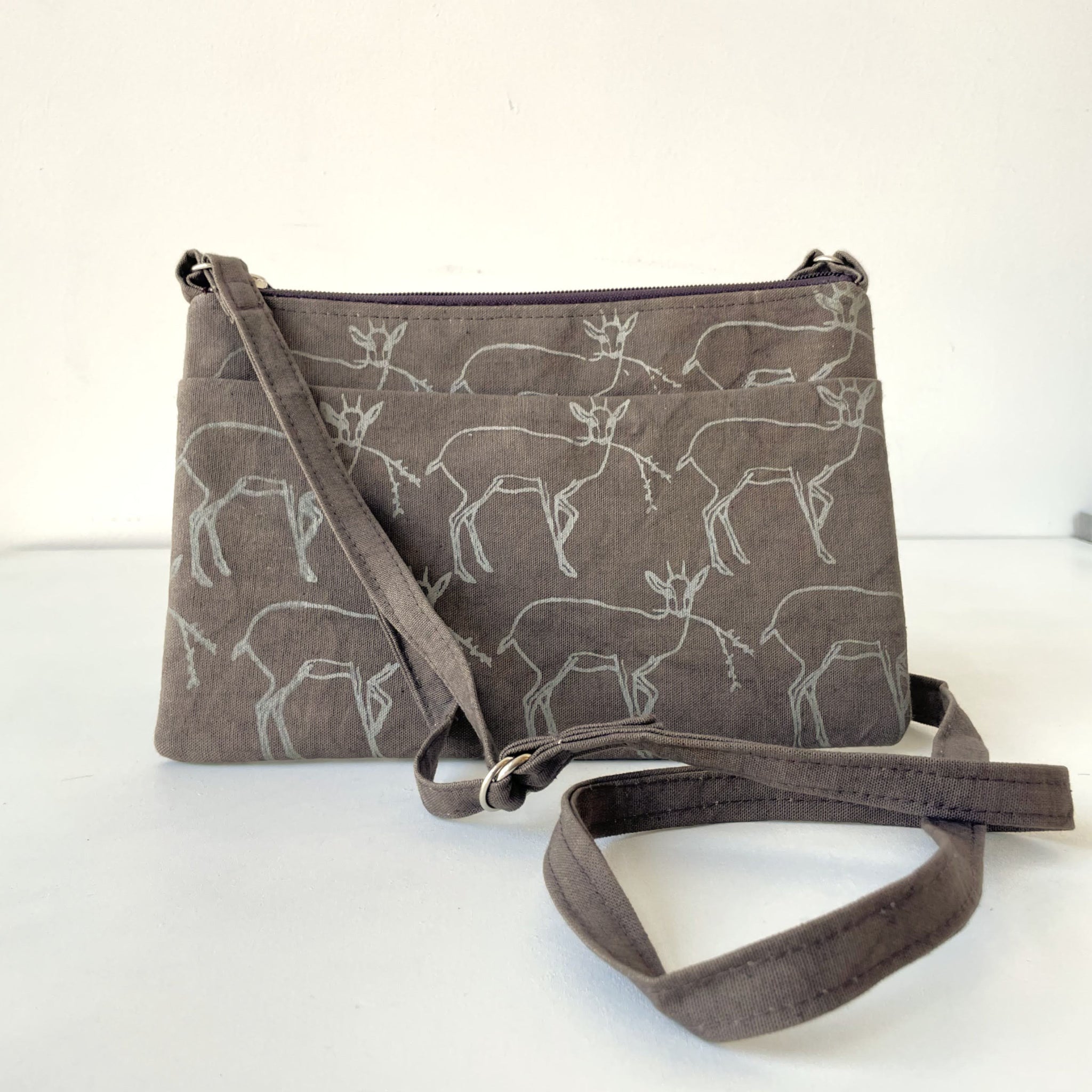 Gray crossbody bag with deer pattern on a white background
