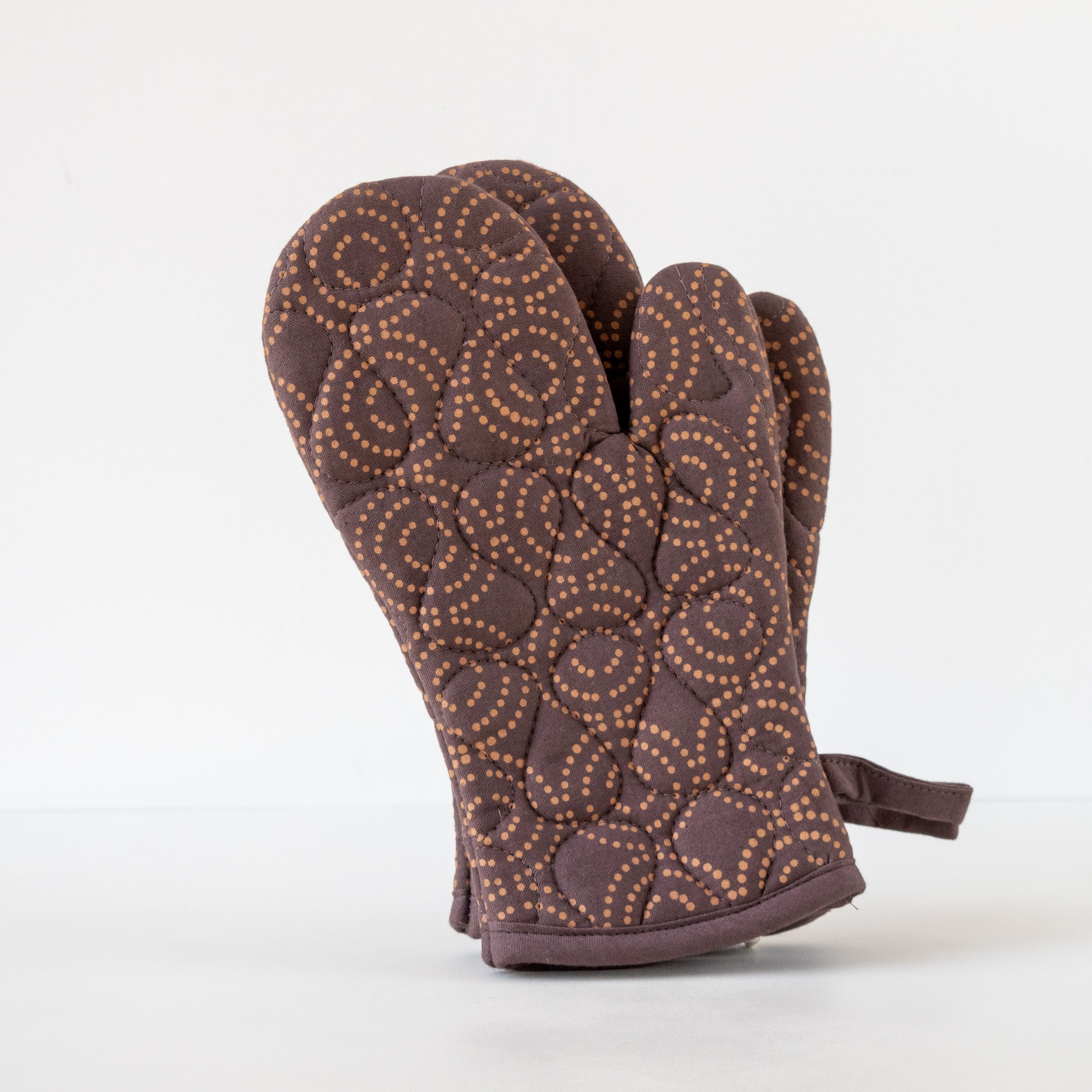 Brown oven mitt with circular pattern on a white background