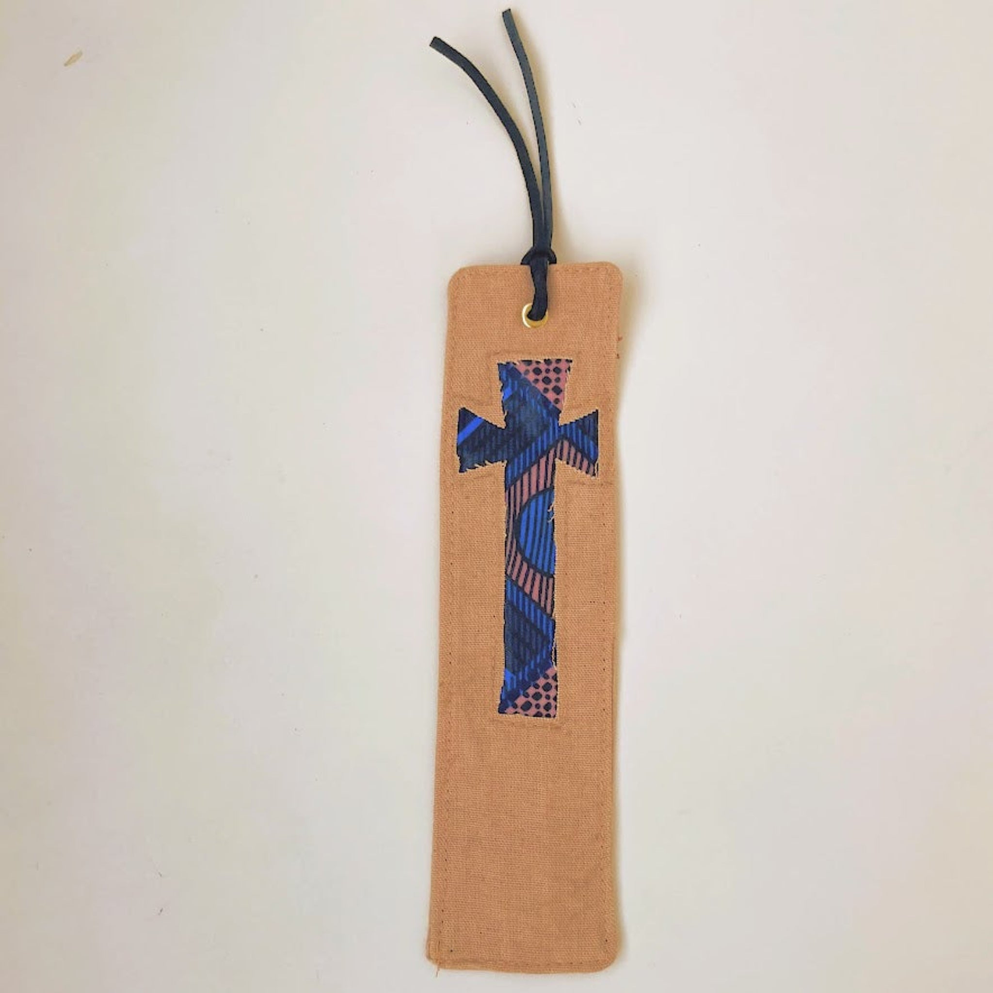 Blush colored Canvas Cross Bookmark on white background.