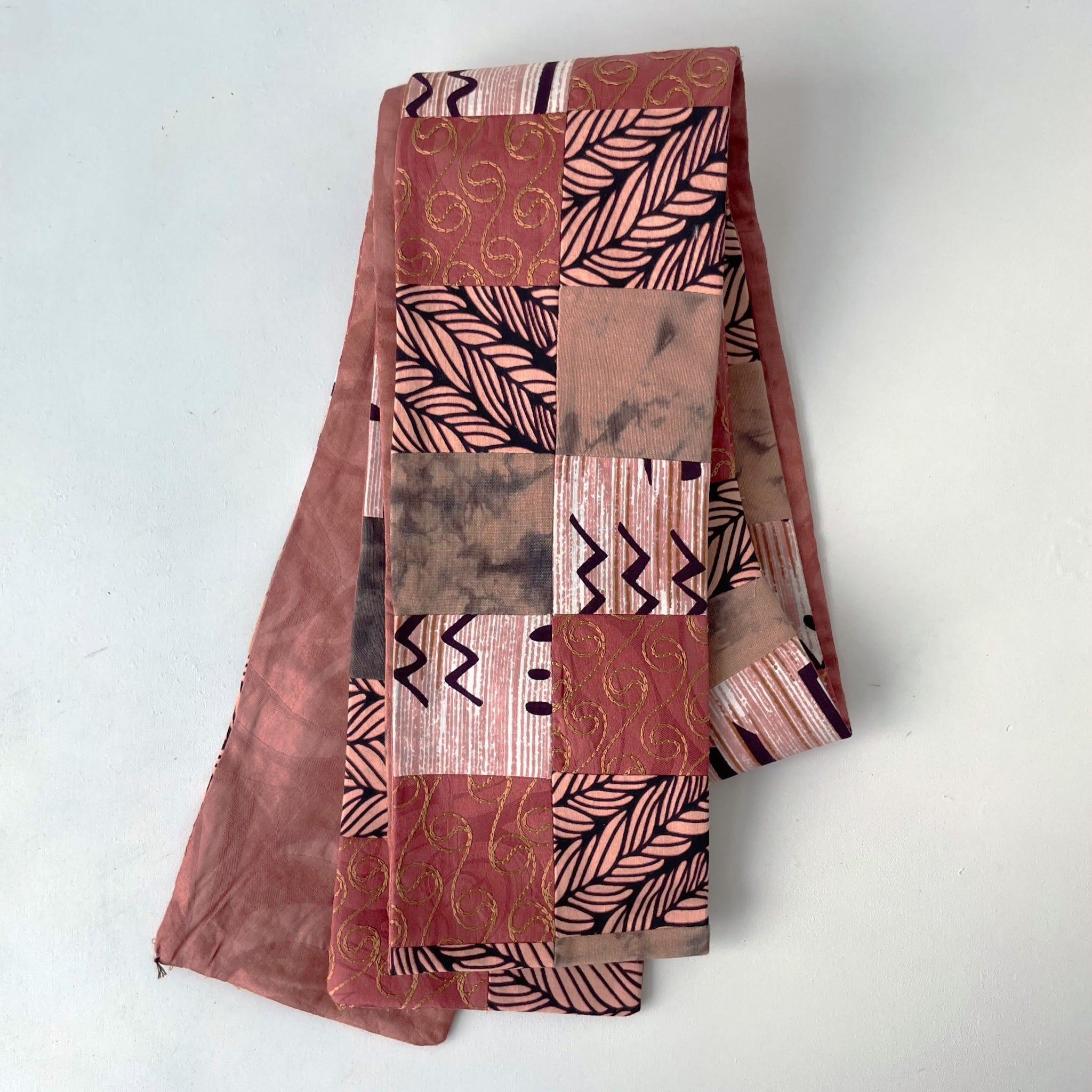 Rose fabric deacon stole with various designs on a white background