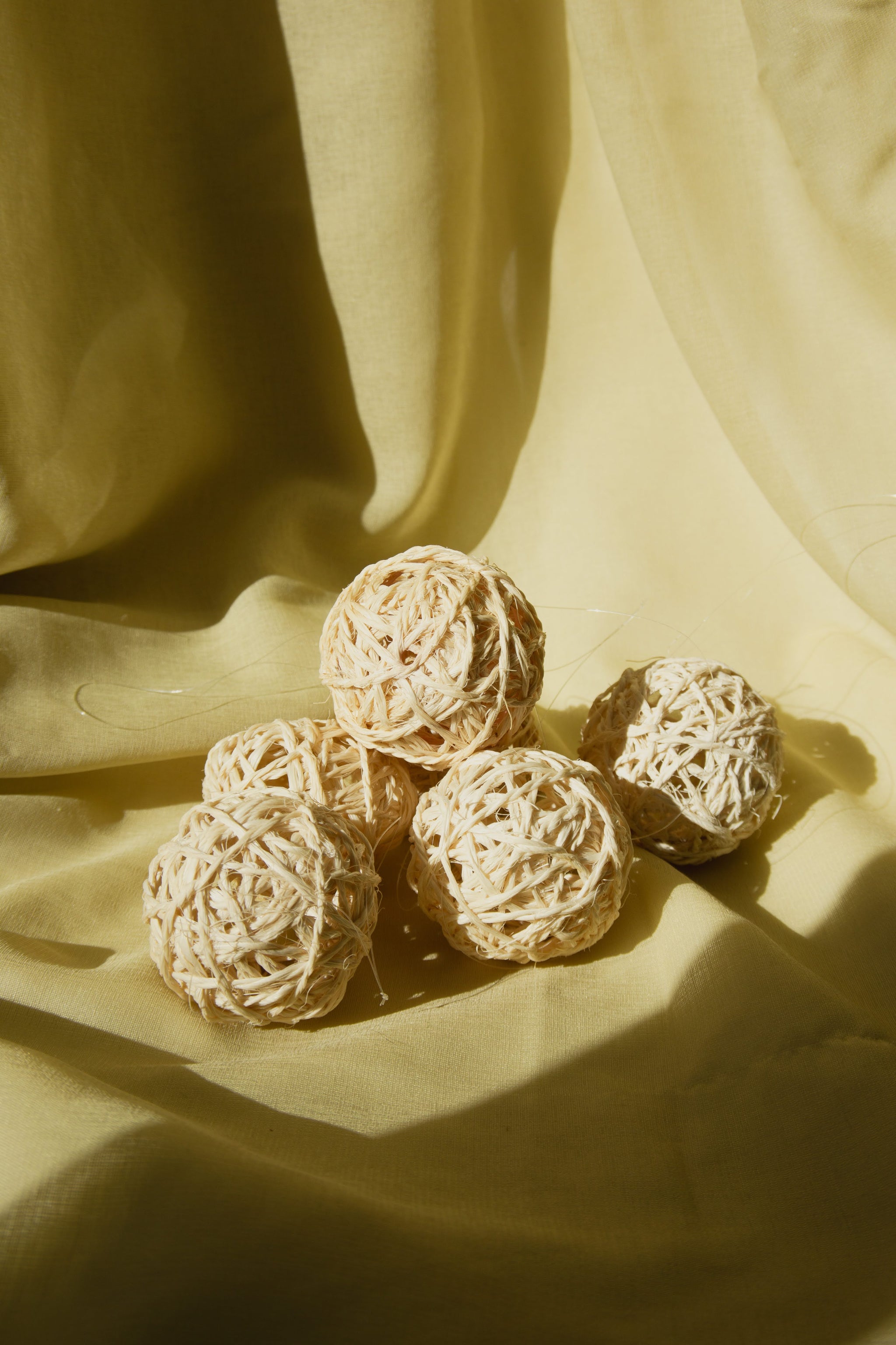 Textured sisal ornaments on a draped fabric background.