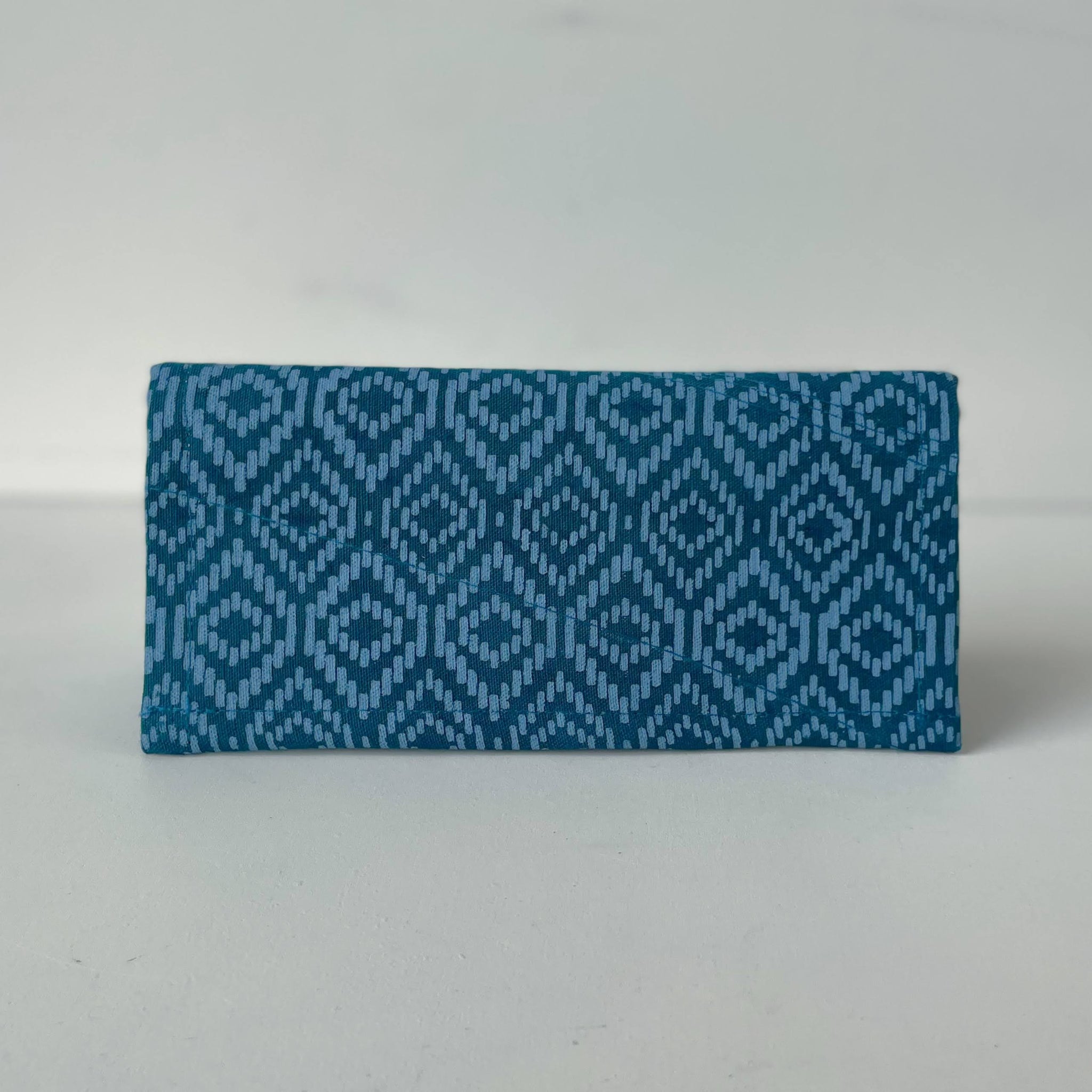 Blue patterned fabric wallet on a white background
