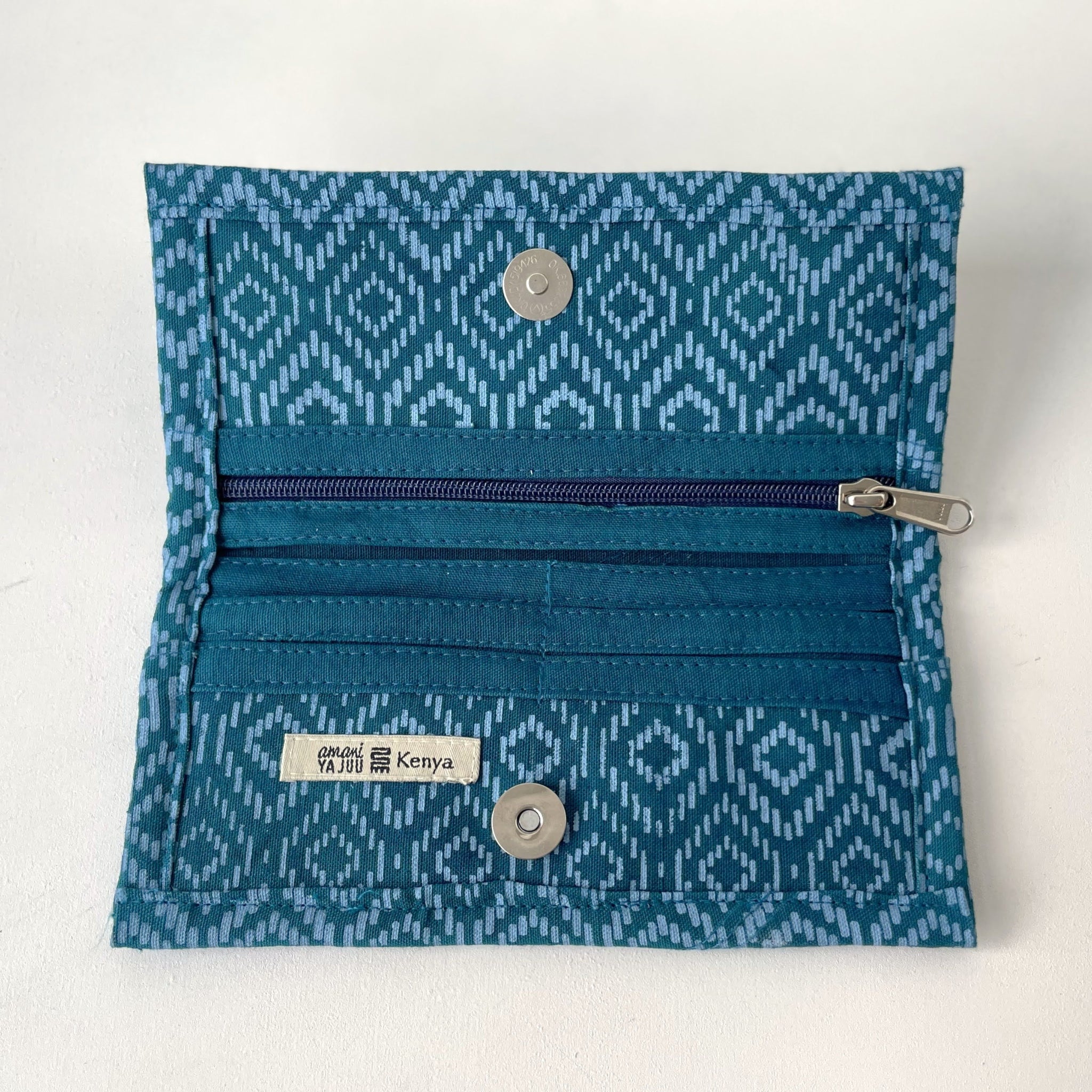 Open blue patterned wallet with a zipper on a white background