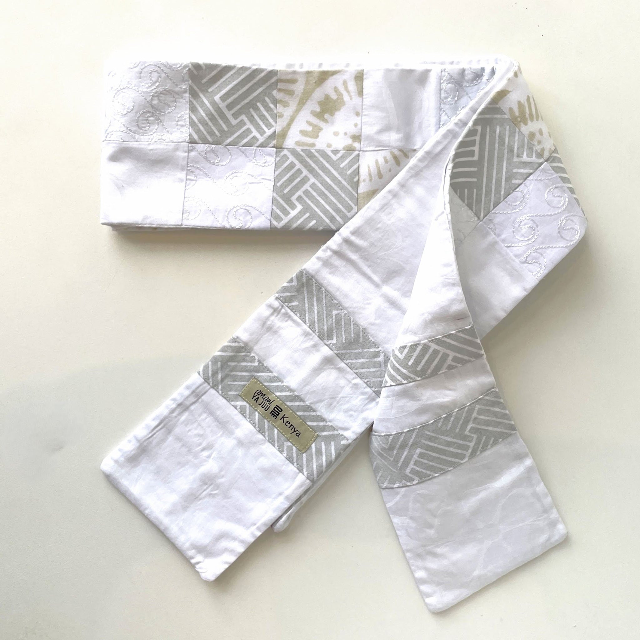 White and gray patterned fabric stole on a light beige background