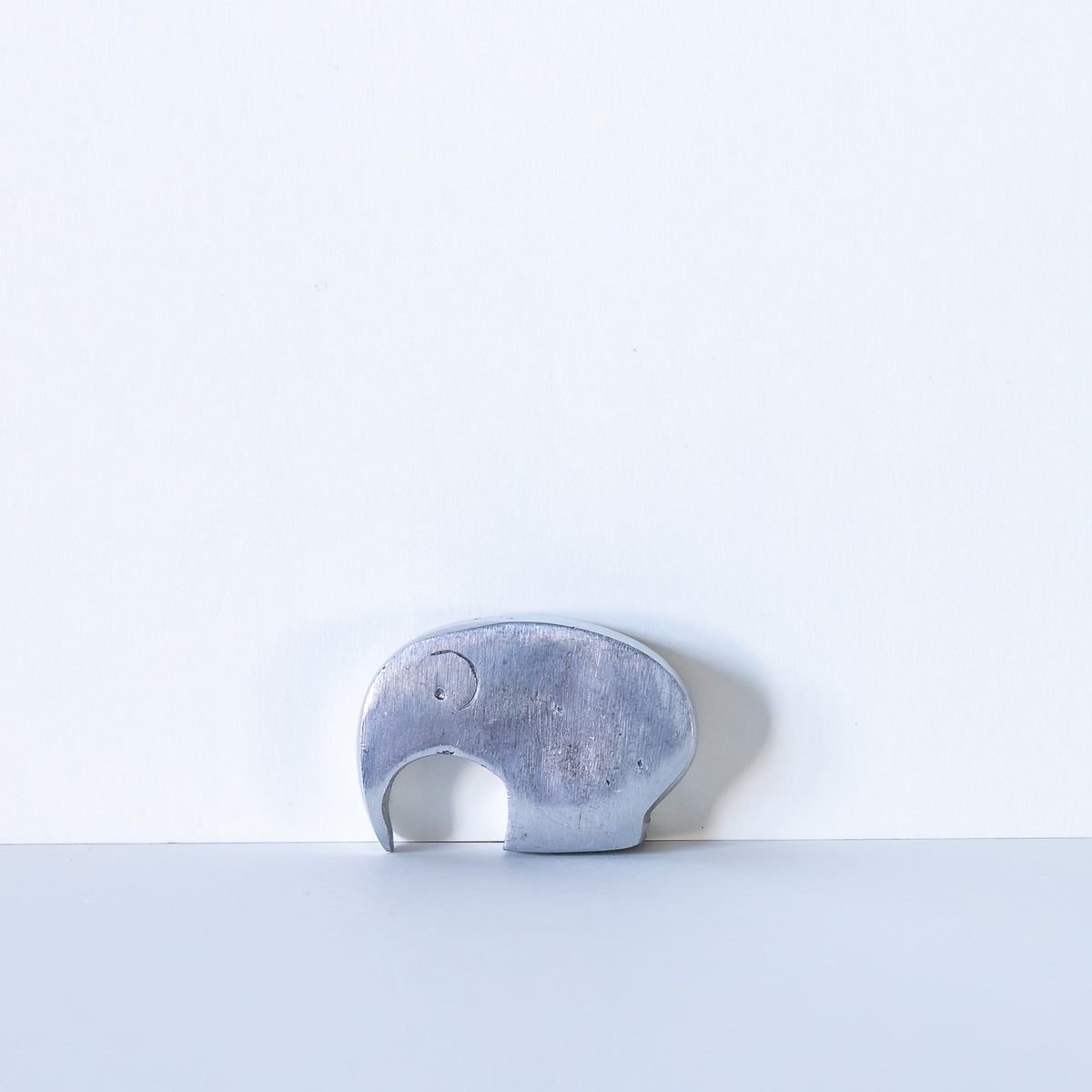 Aluminum elephant shaped bottle opener on a white background