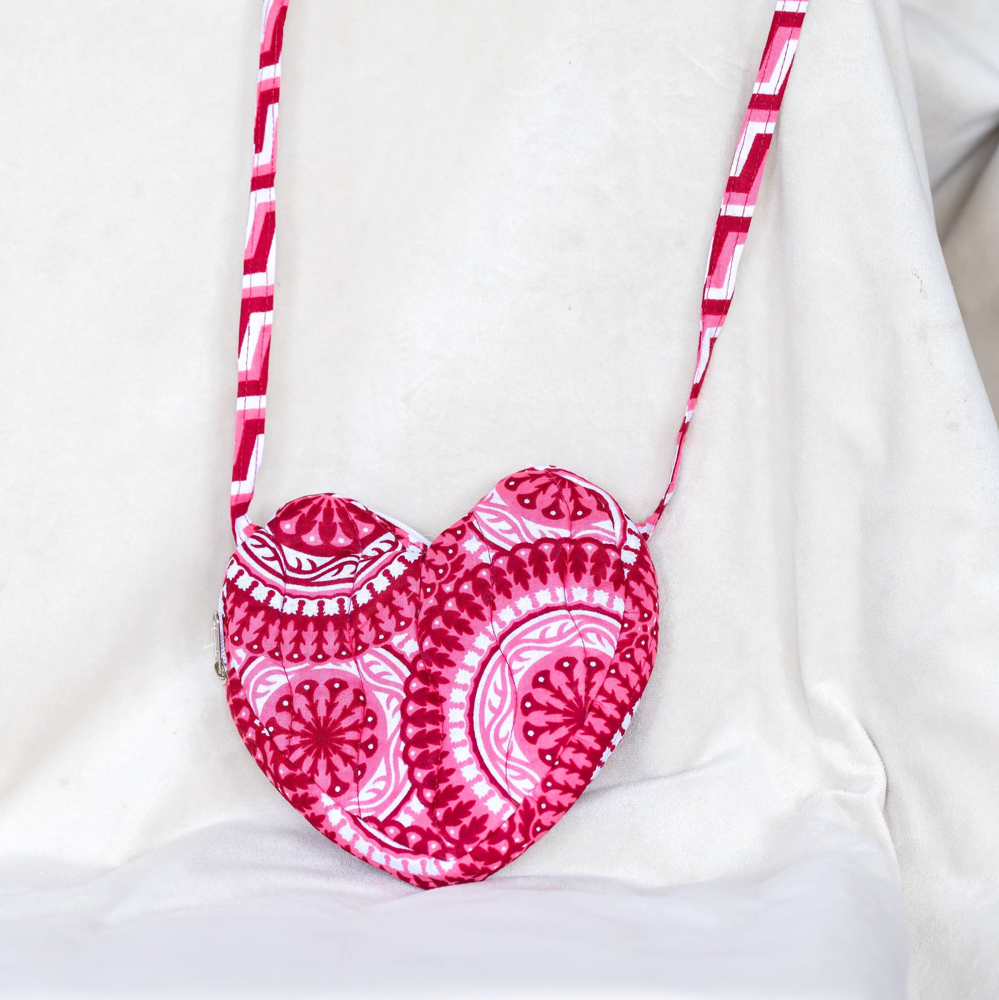 Pink and white heart shaped quilted purse on white background