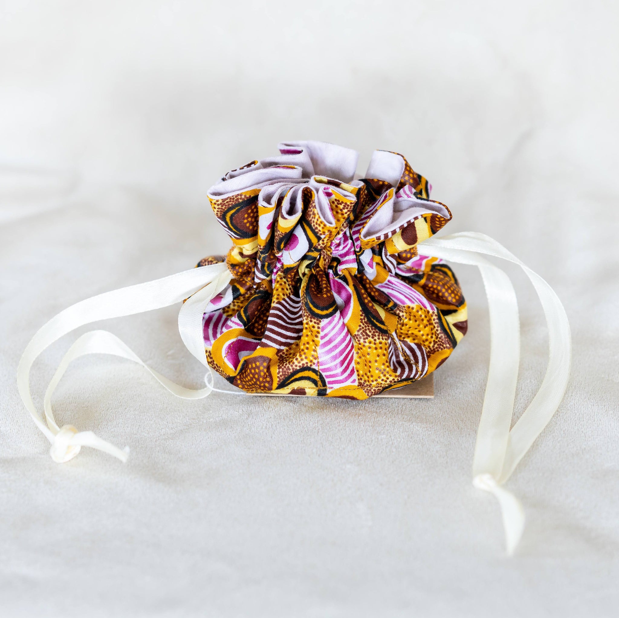 Gold and purple earring travel pouch on white background