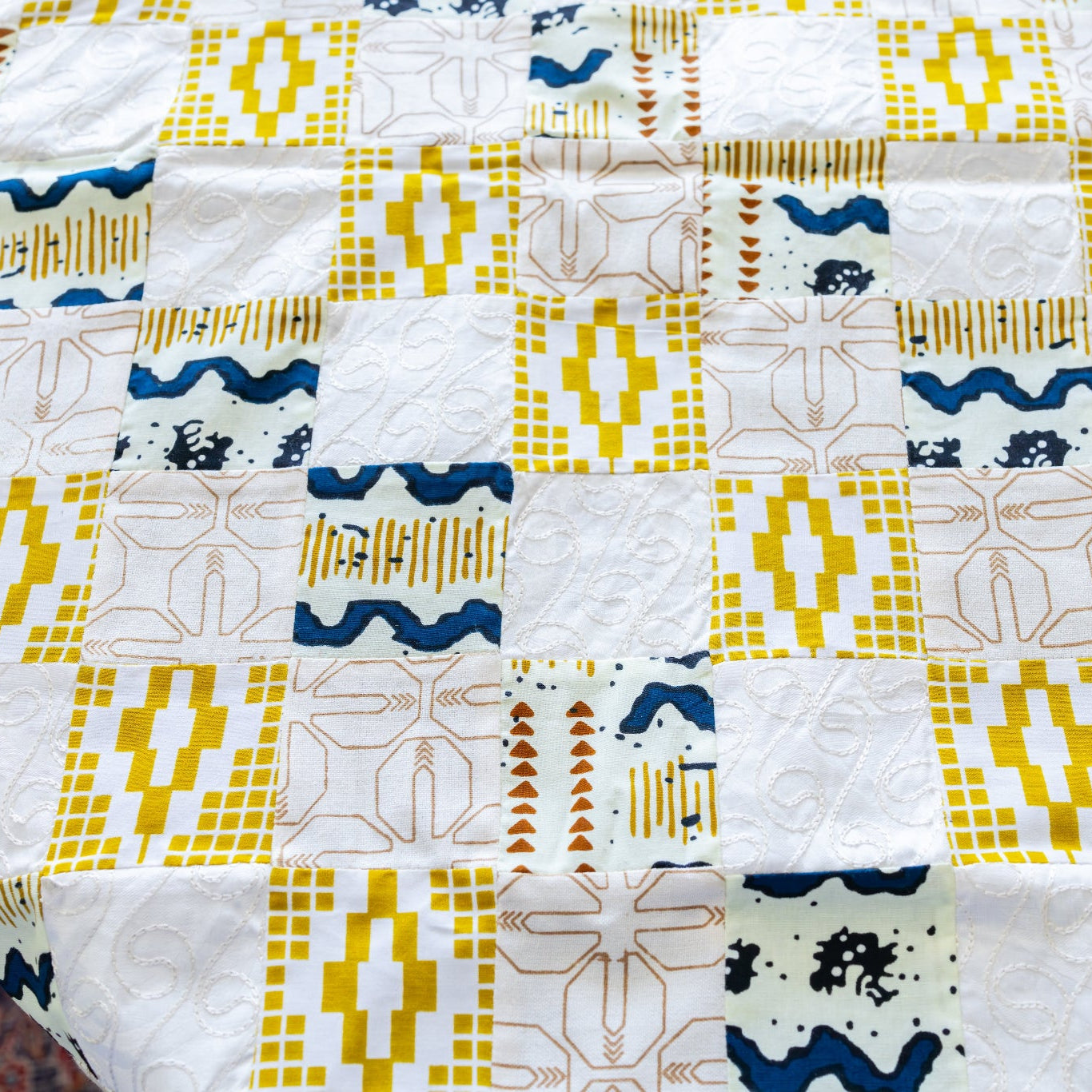Detail of a gold, white, and blue patchwork table runner