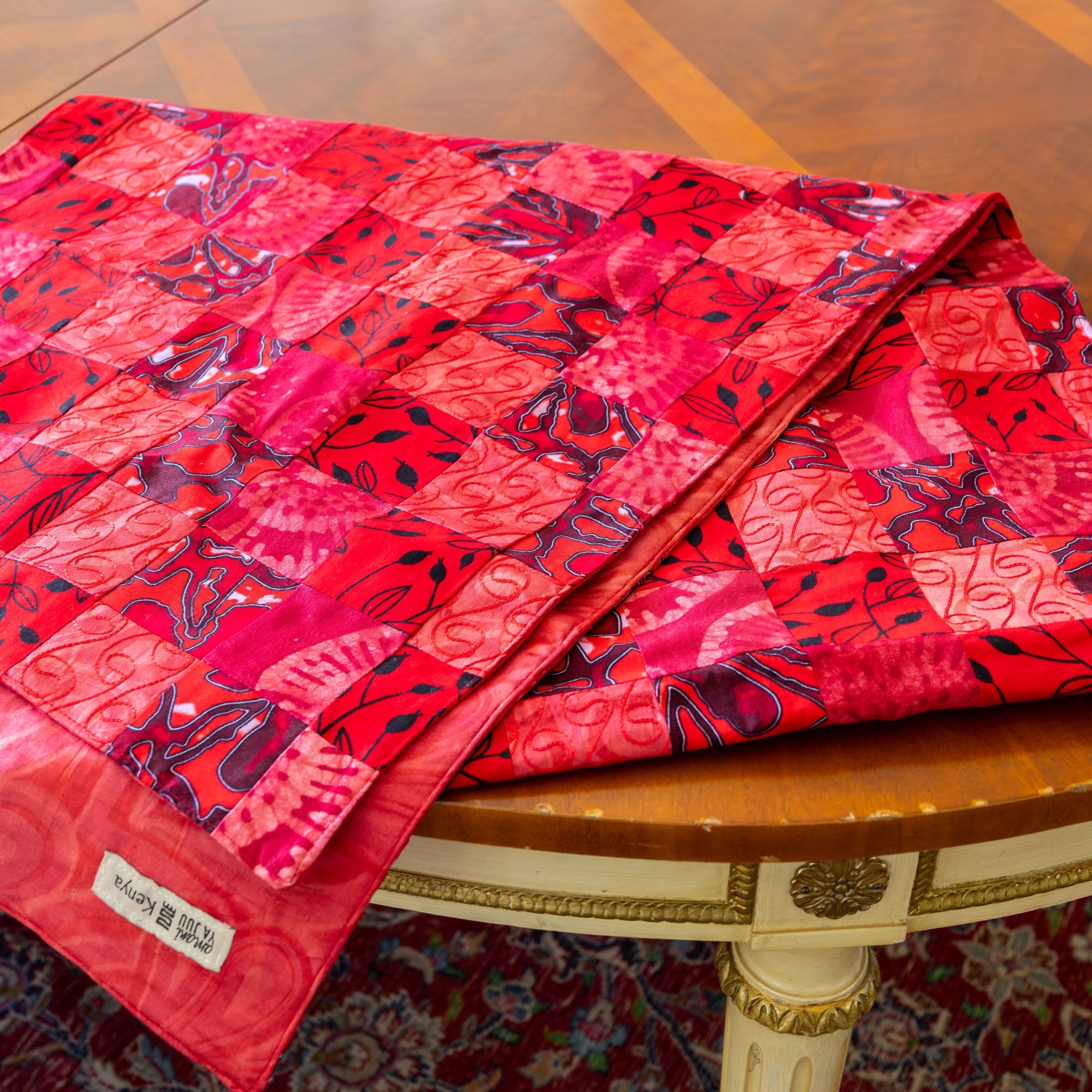 Folded red patchwork table runner on wooden table