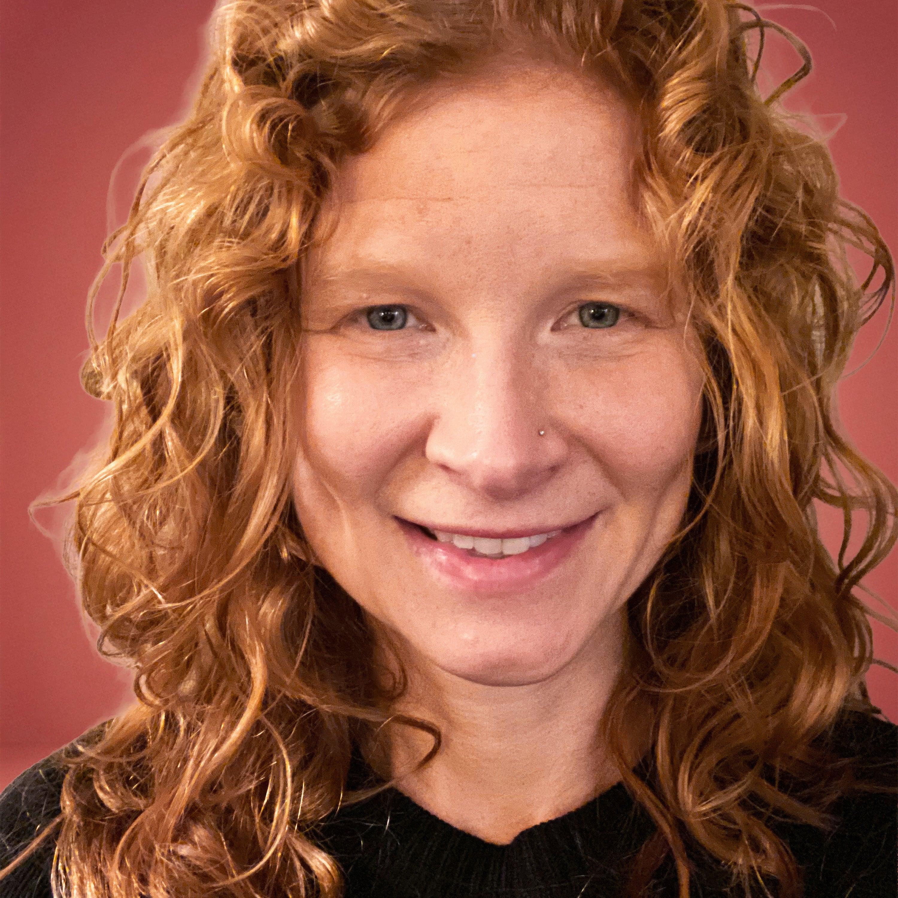 Woman with curly red hair against a pink background