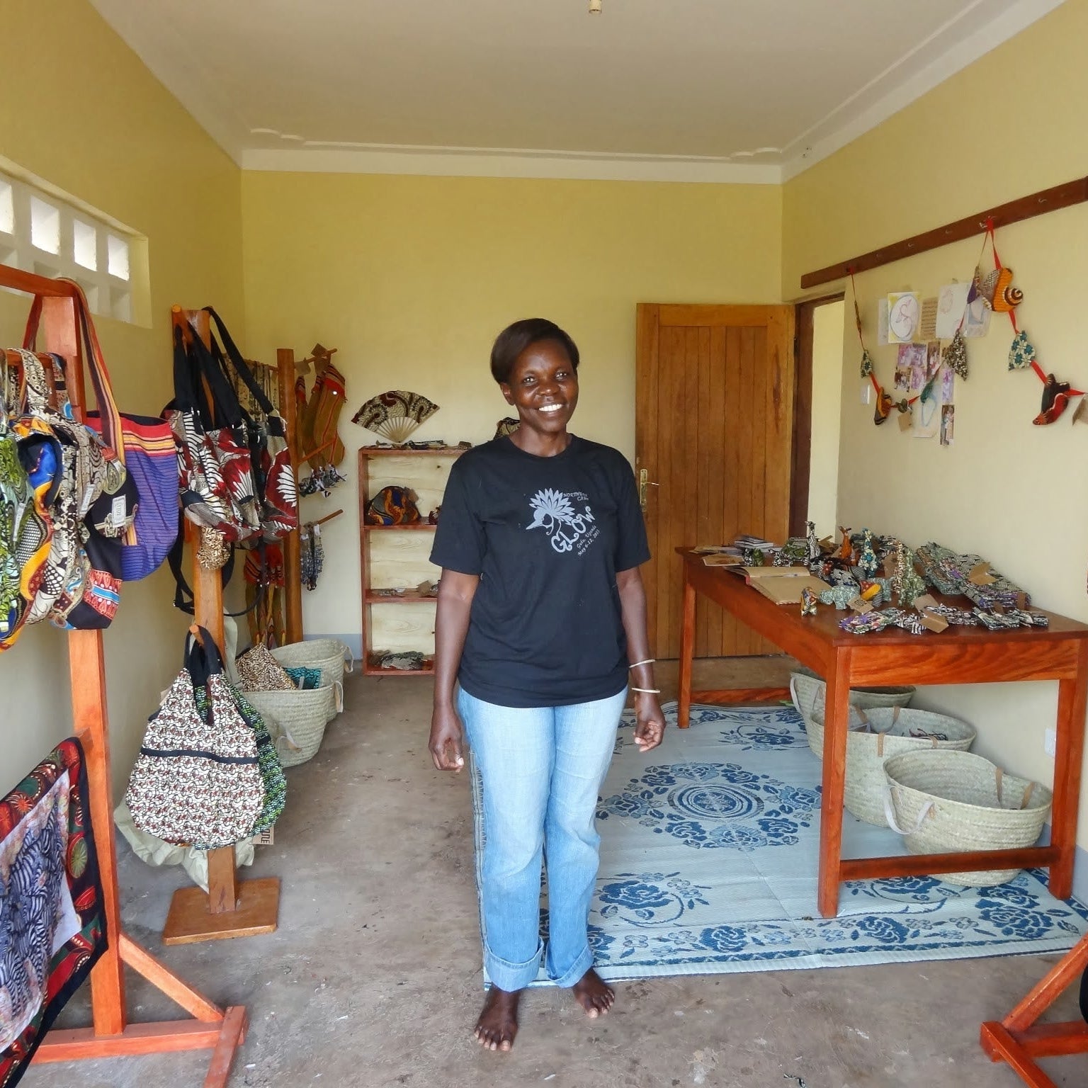 Woman standing in a showroom with clothing racks and a table.