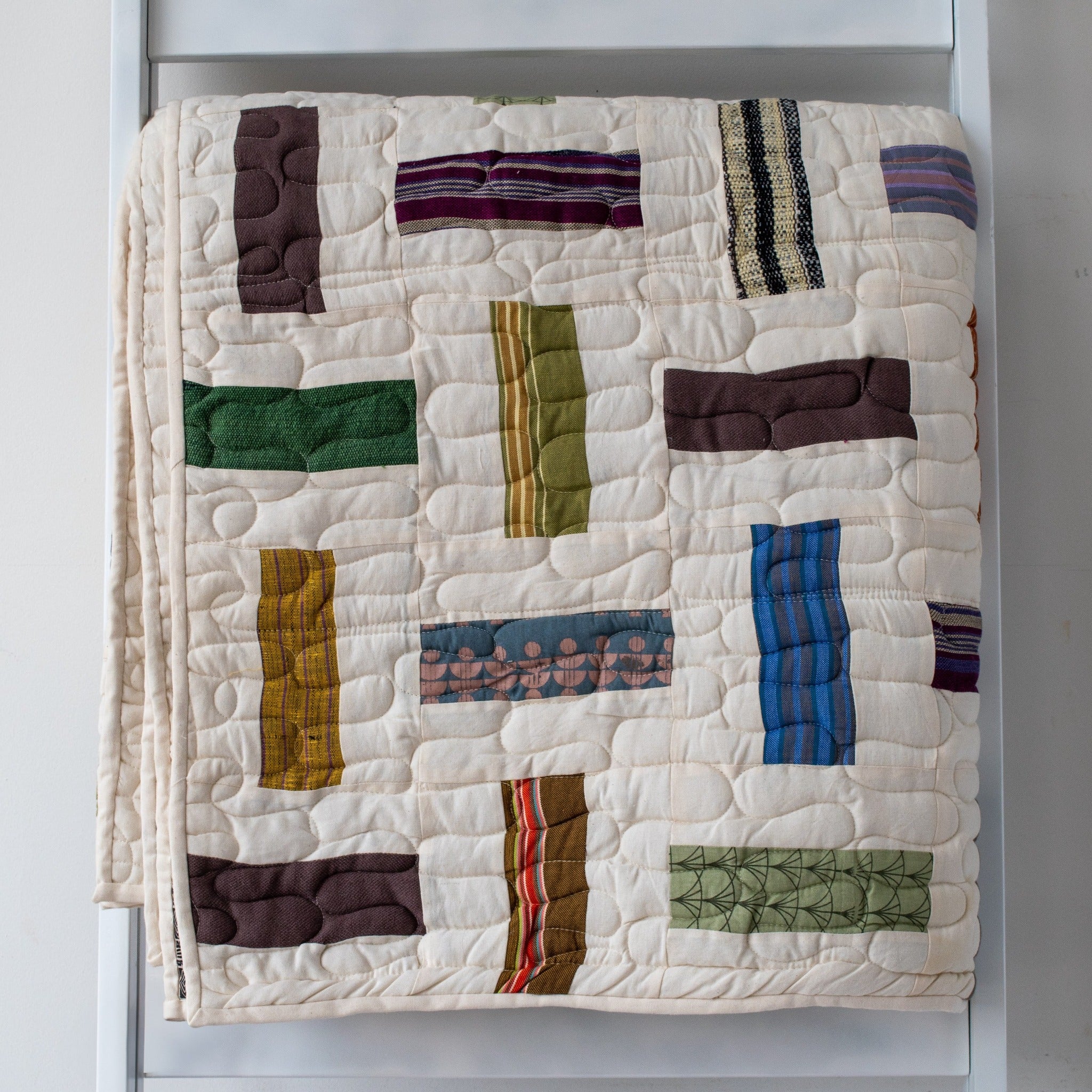 A handmade Kenyan quilt - cotton cloth hand stitched together by the Amani women for a Fair Trade boutique