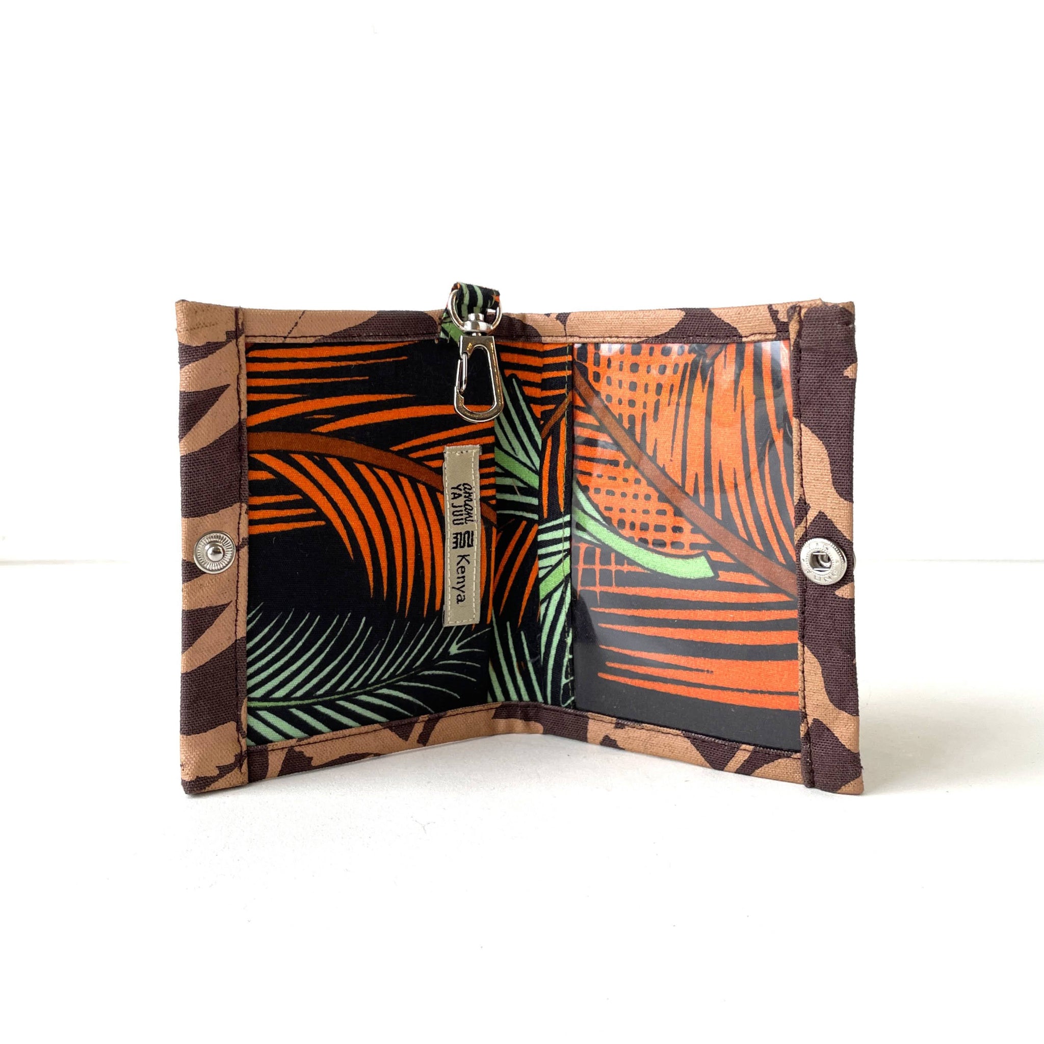 Fabric wallet with tropical leaf pattern on a white background