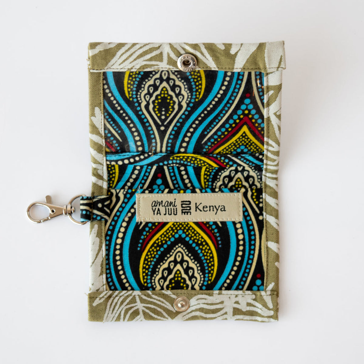 A small fabric card holder with a colorful abstract pattern in blue, yellow, black, and white, attached to an olive green strap with a silver clasp. A fabric label on the front reads 'amni YA JUU Kenya'.
