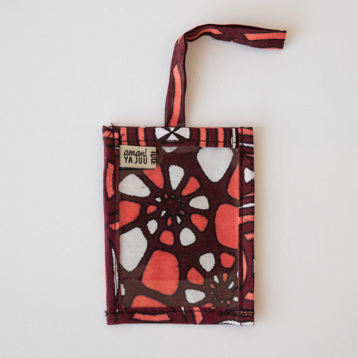 Maroon and coral fabric luggage tag on white background