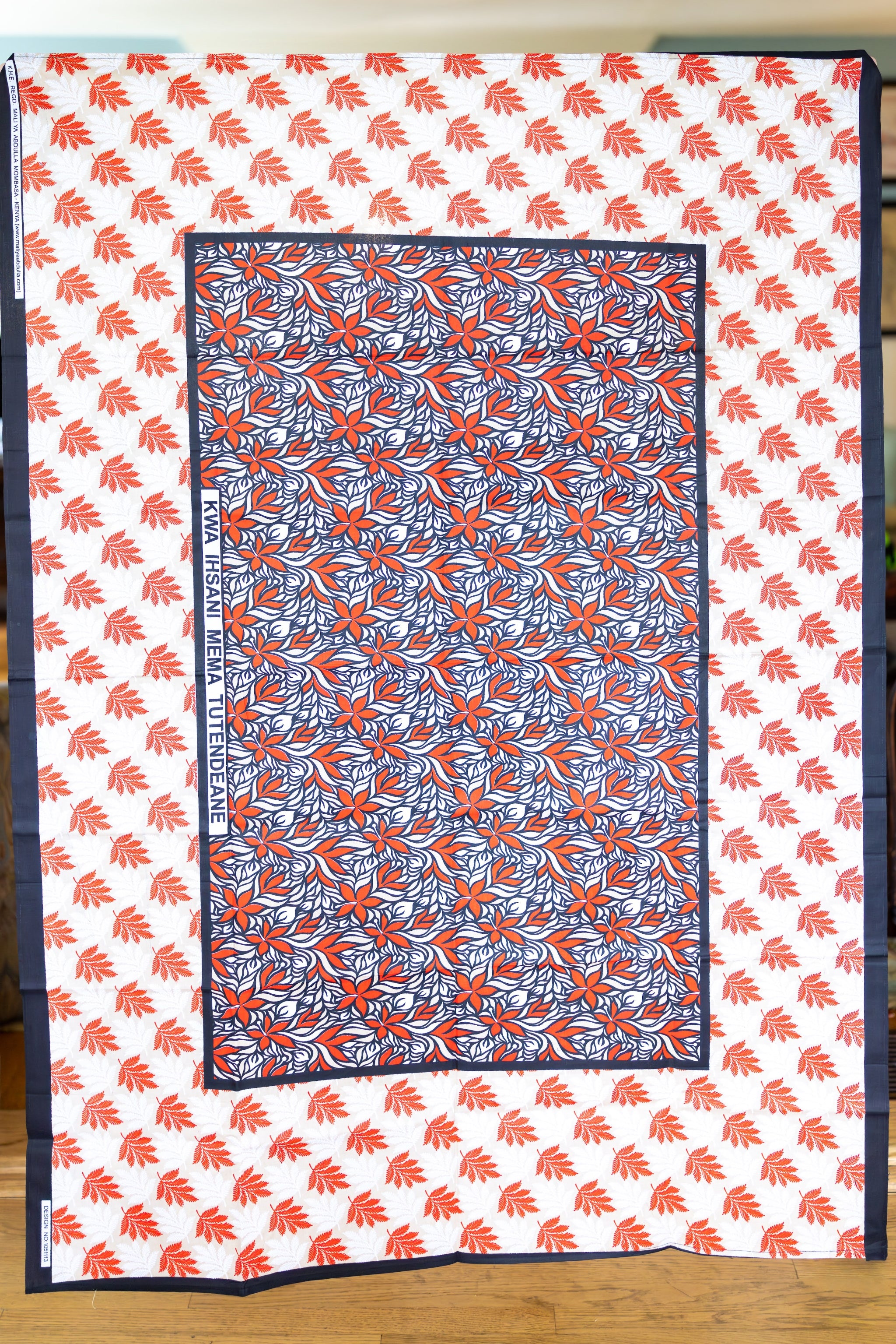 Large scarf in red, white, tan, and black with hibiscus flowers and fern leaves.