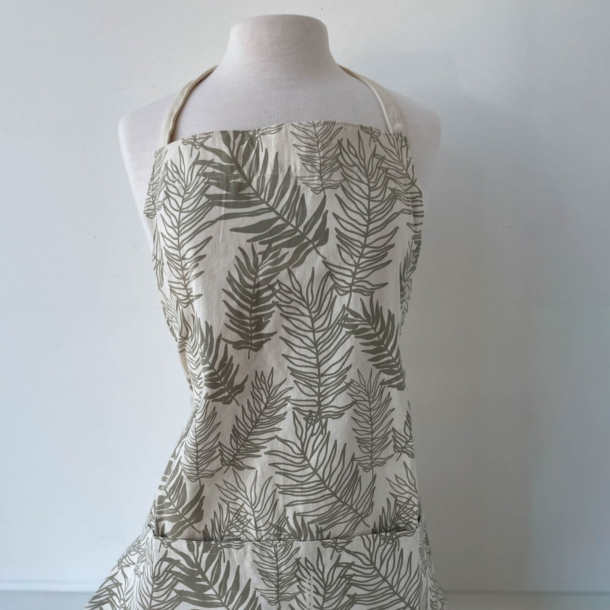Floral-patterned apron on a mannequin against a white background