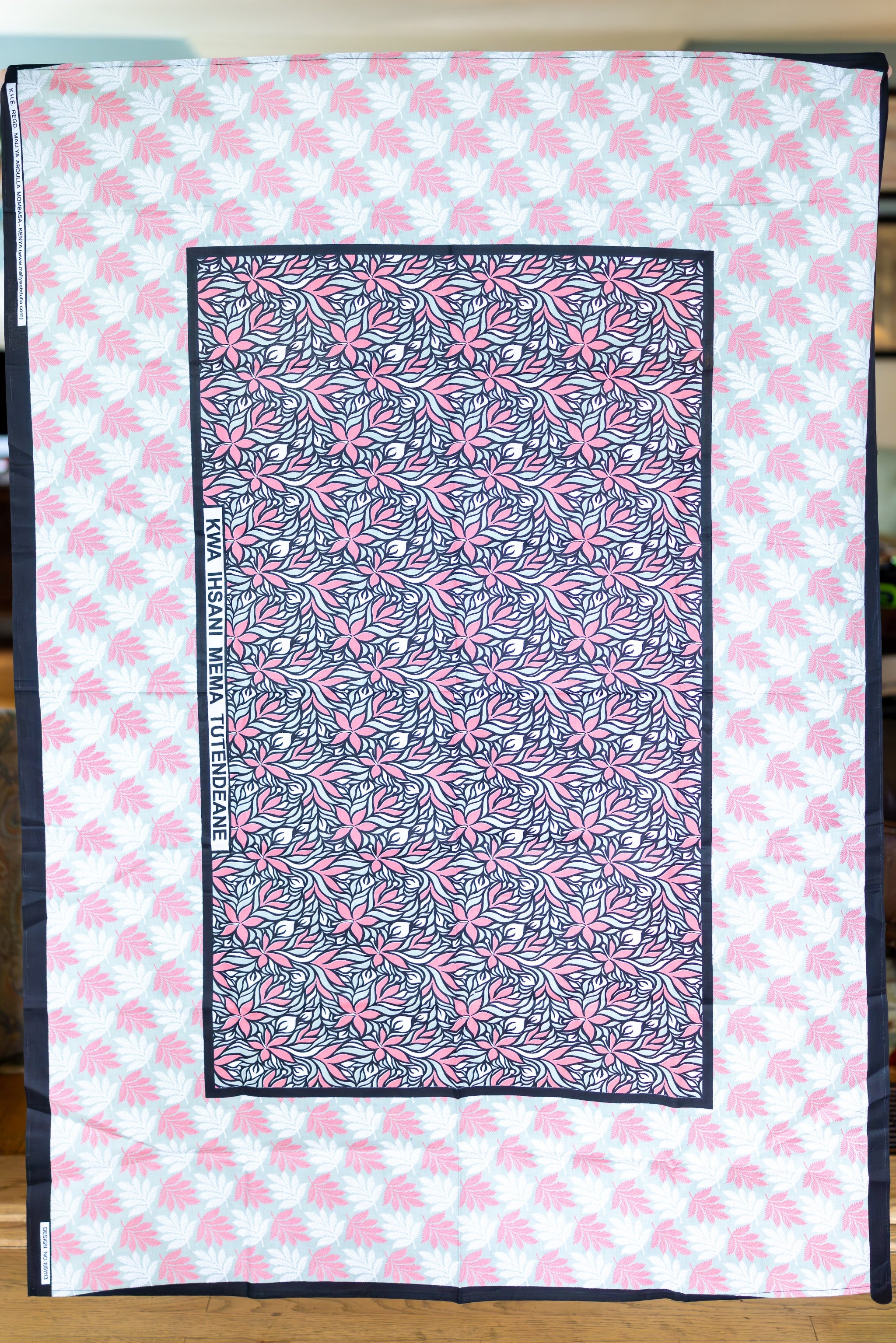 Large scarf in salmon, white, tan, and black with hibiscus flowers and fern leaves.
