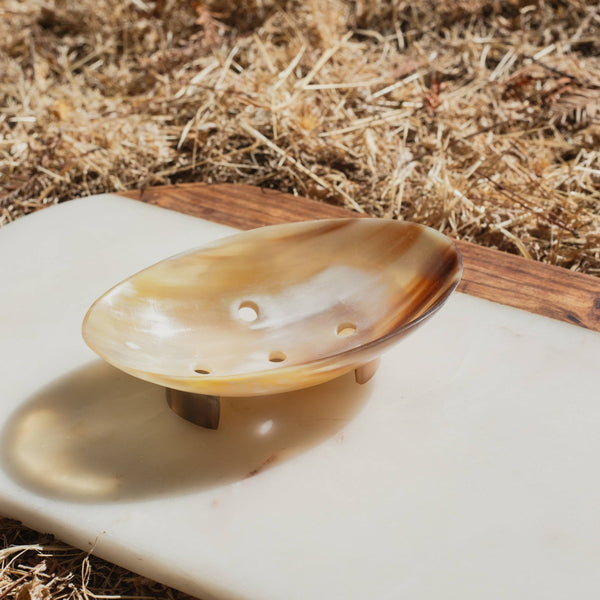 Horn soap dish on a stone surface with straw background