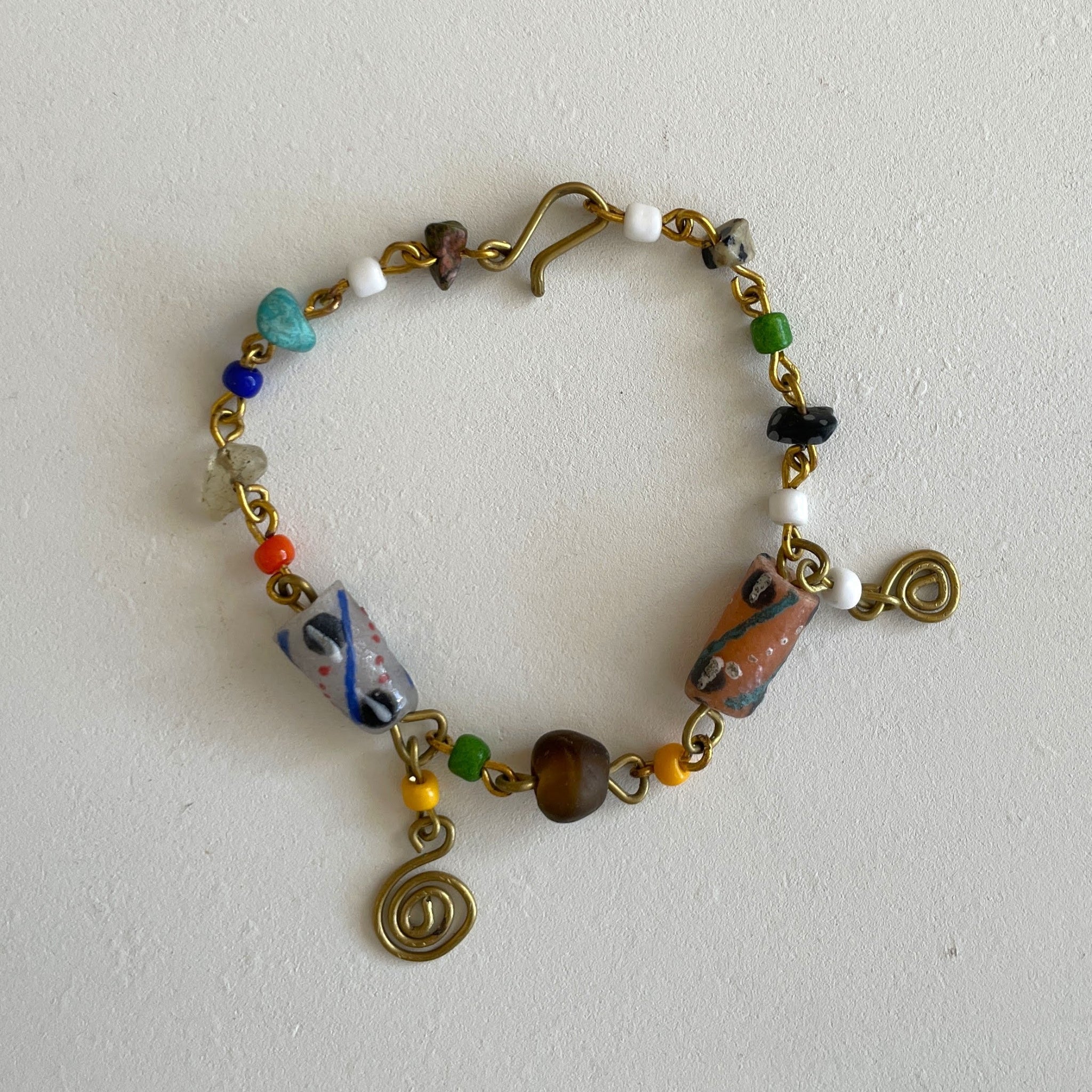 Colorful beaded bracelet with gold accents on a white background
