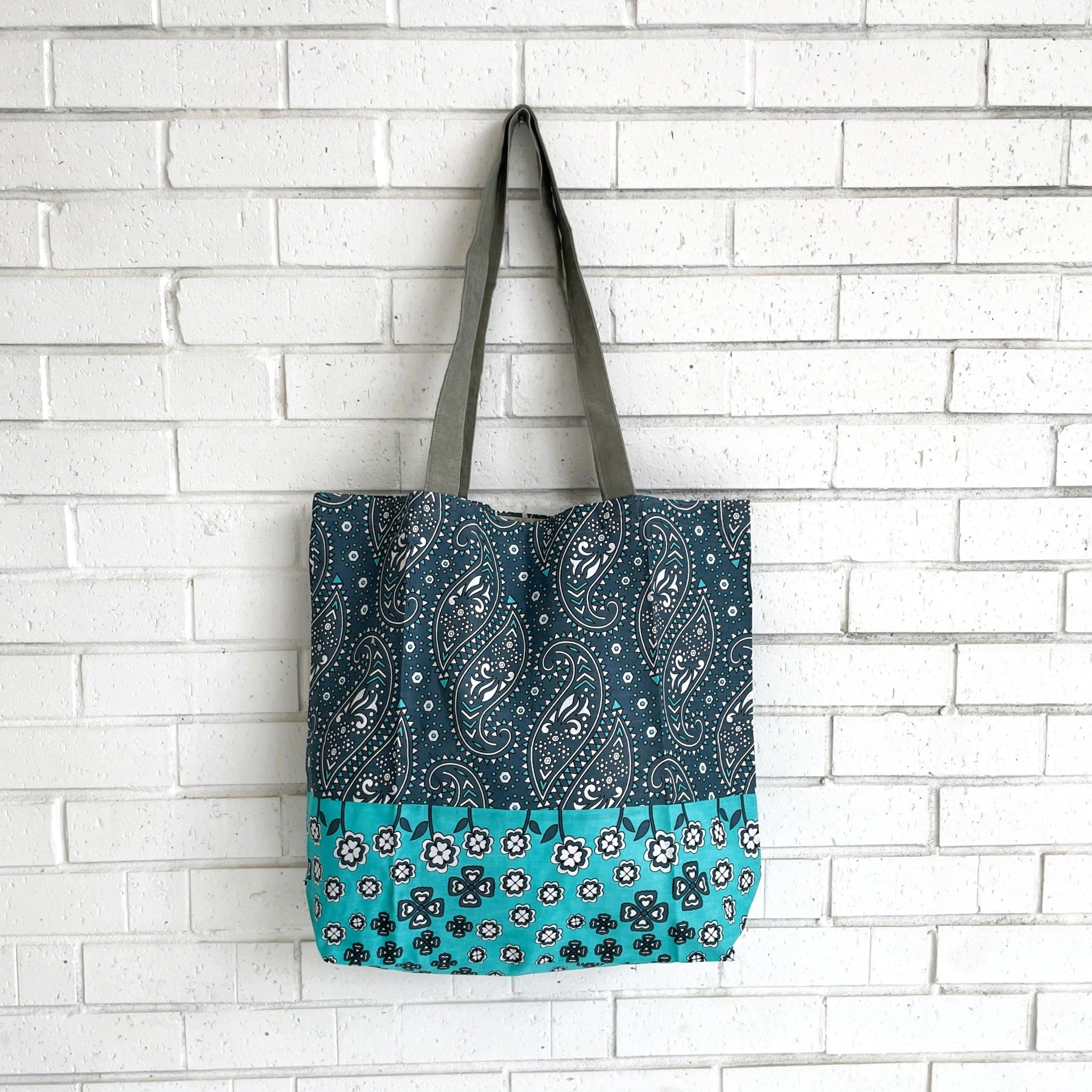 Tote bag with paisley pattern on a white brick wall