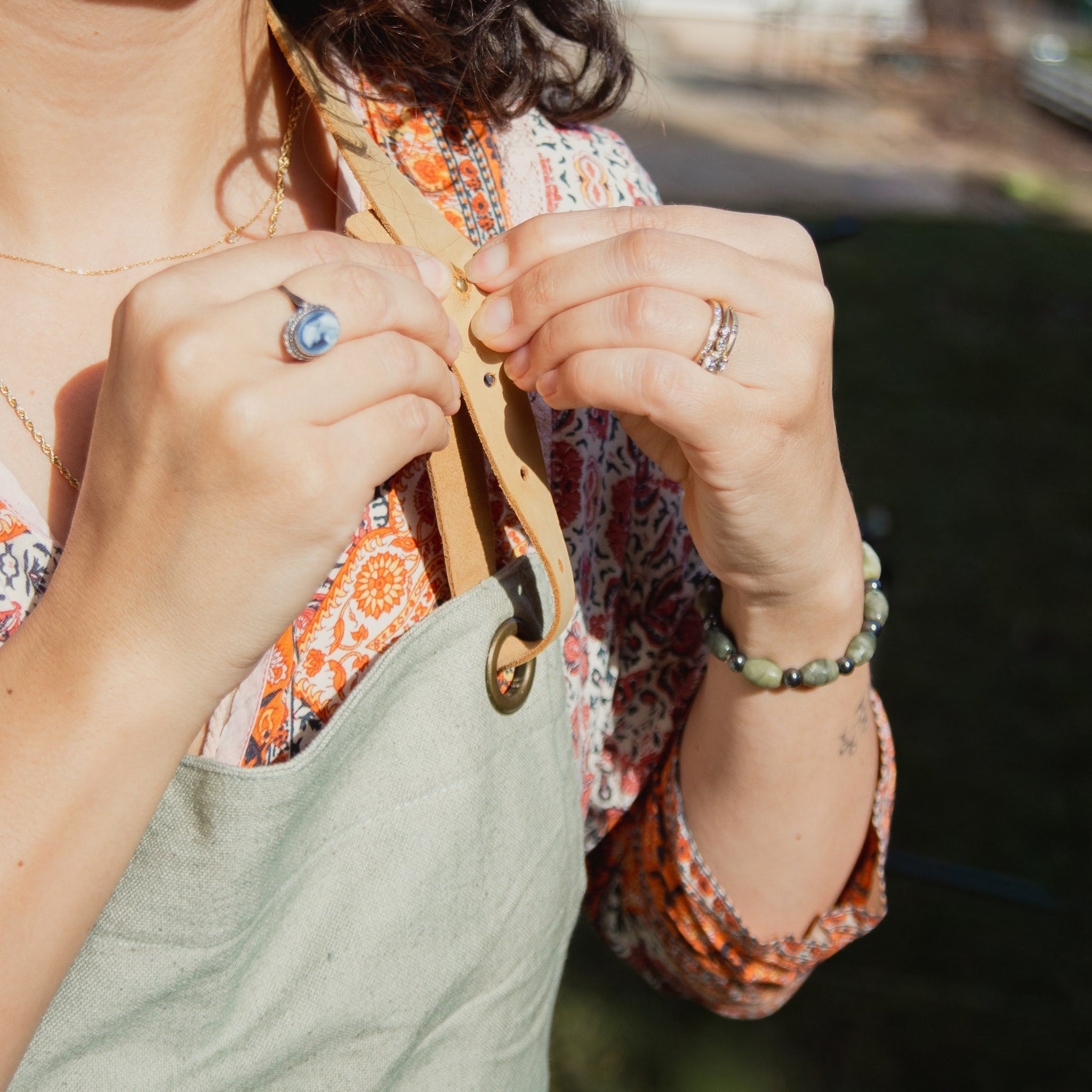 Person wearing a green apron with a blurred background