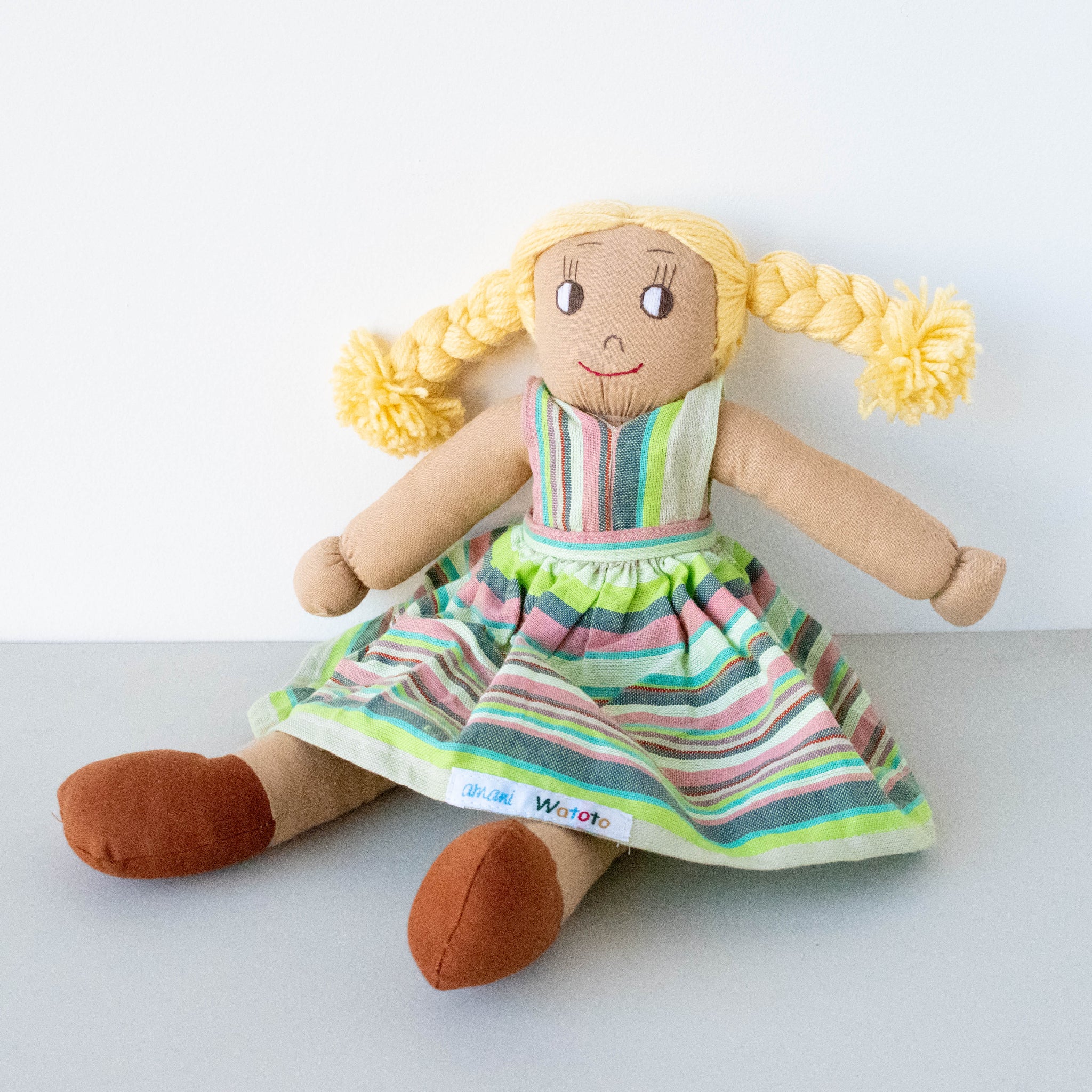 Plush doll with a striped dress on a white background