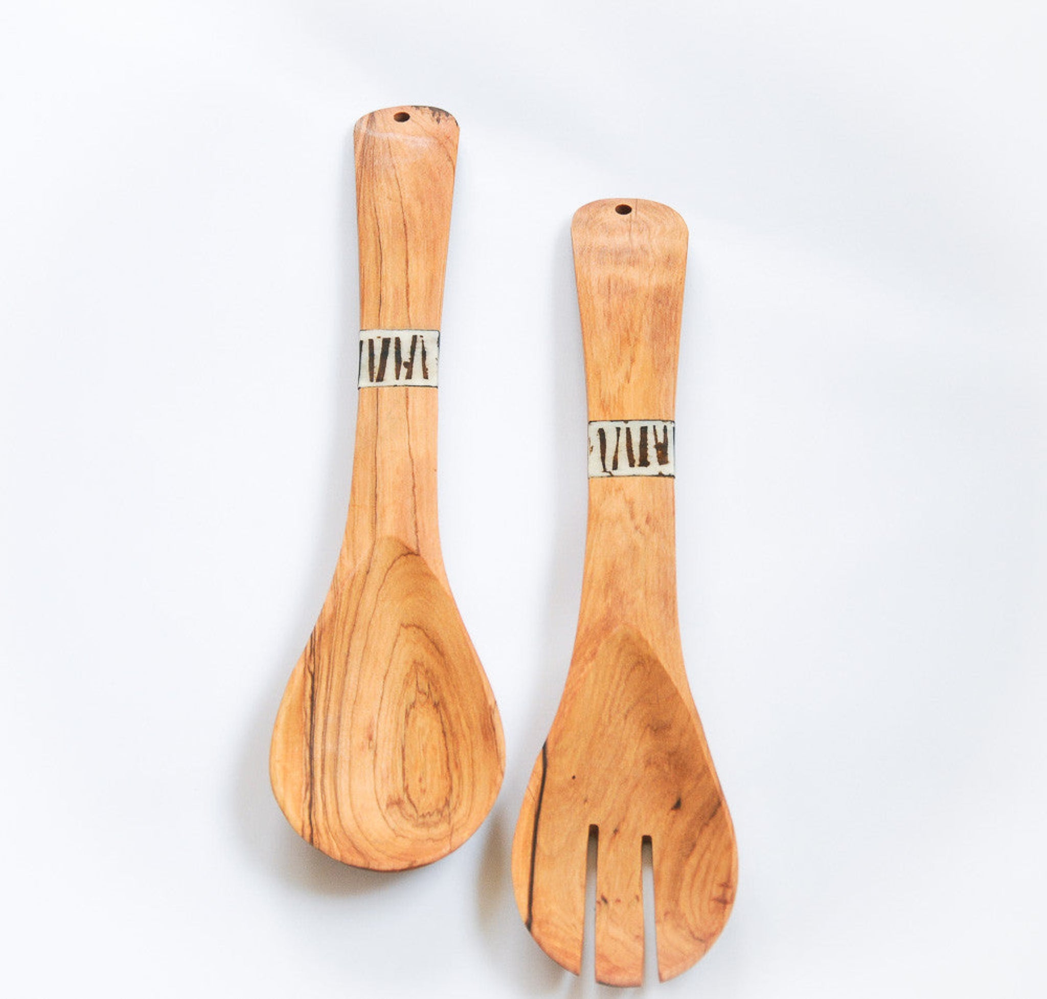 Two wooden salad serving utensils, a spoon and a fork, with natural wood grain and a bone band near the handles, displayed on a clean white background.
