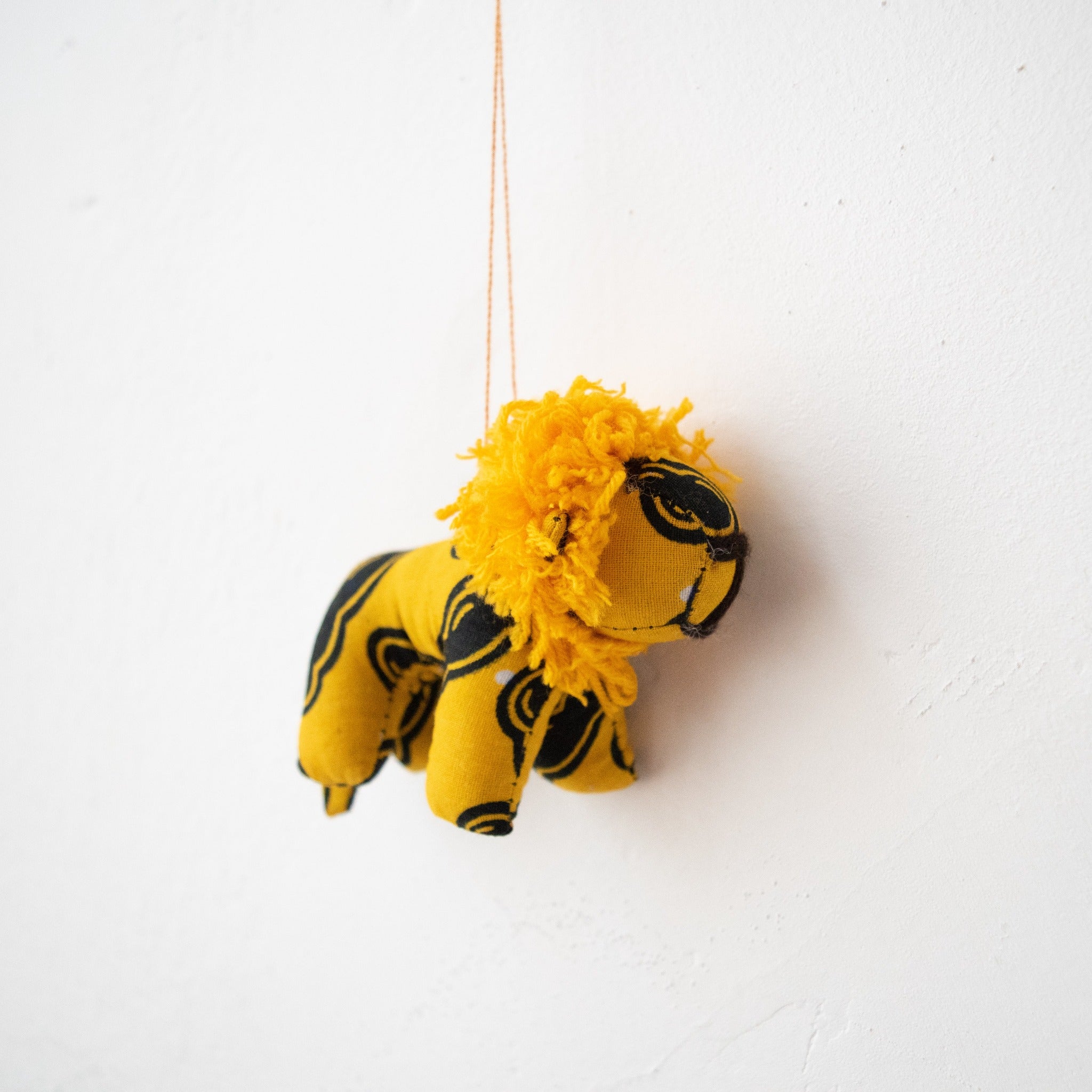 Stuffed lion ornament hanging on white background