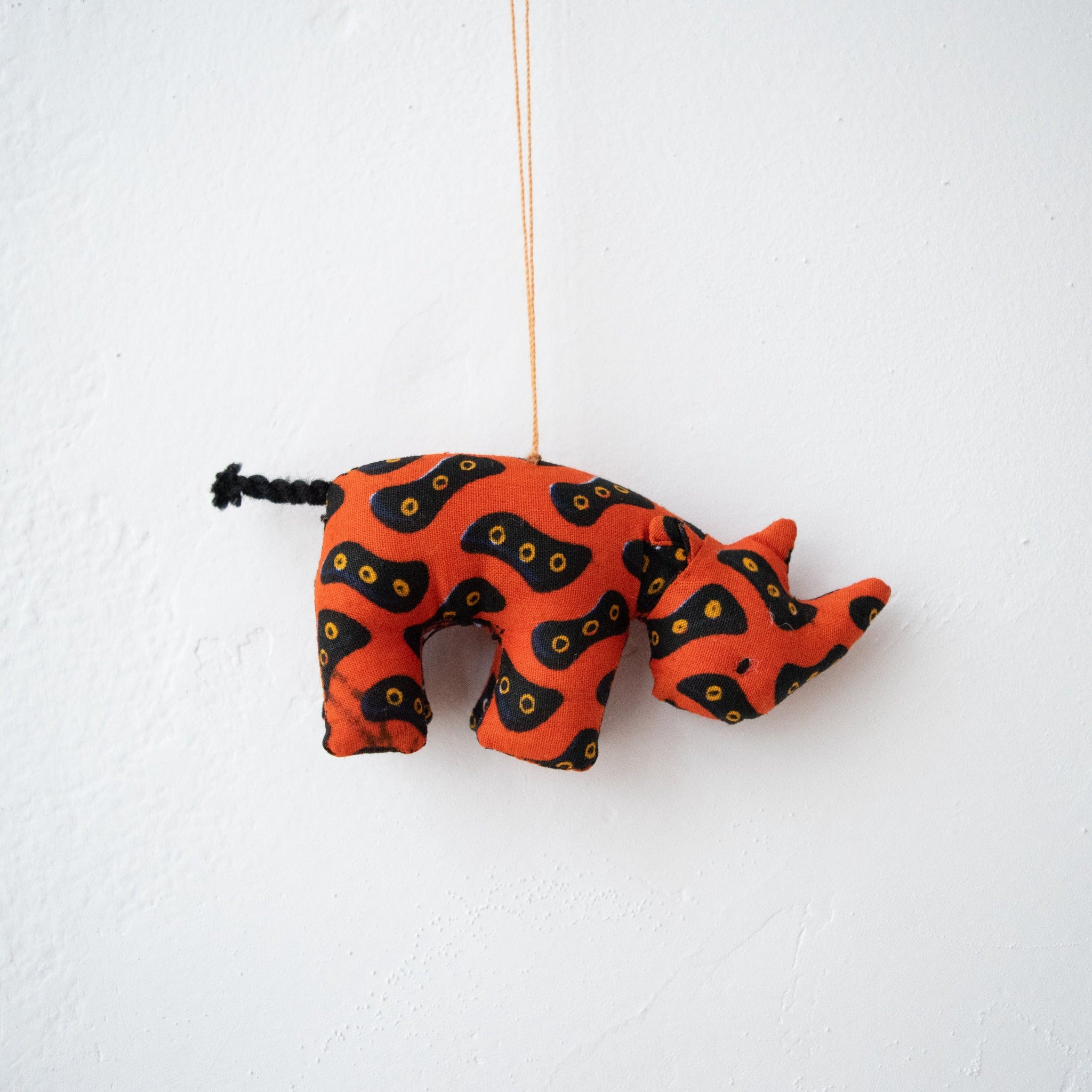 Stuffed rhino ornament hanging on white background