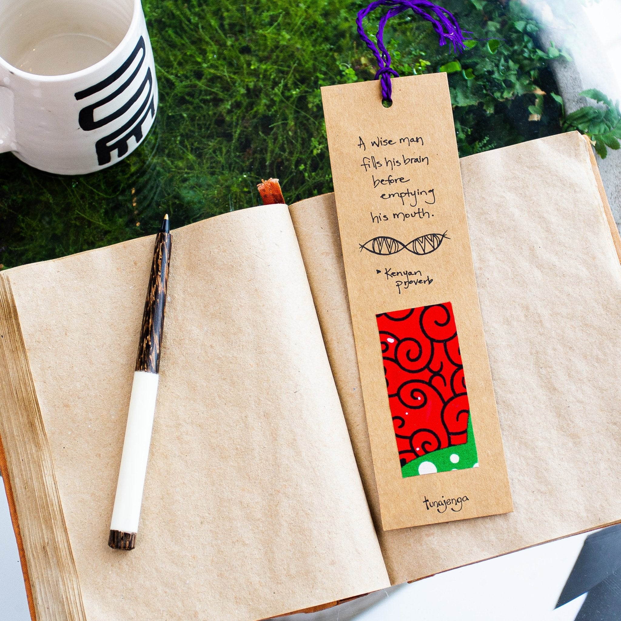 African proverb bookmark with red fabric on an open book