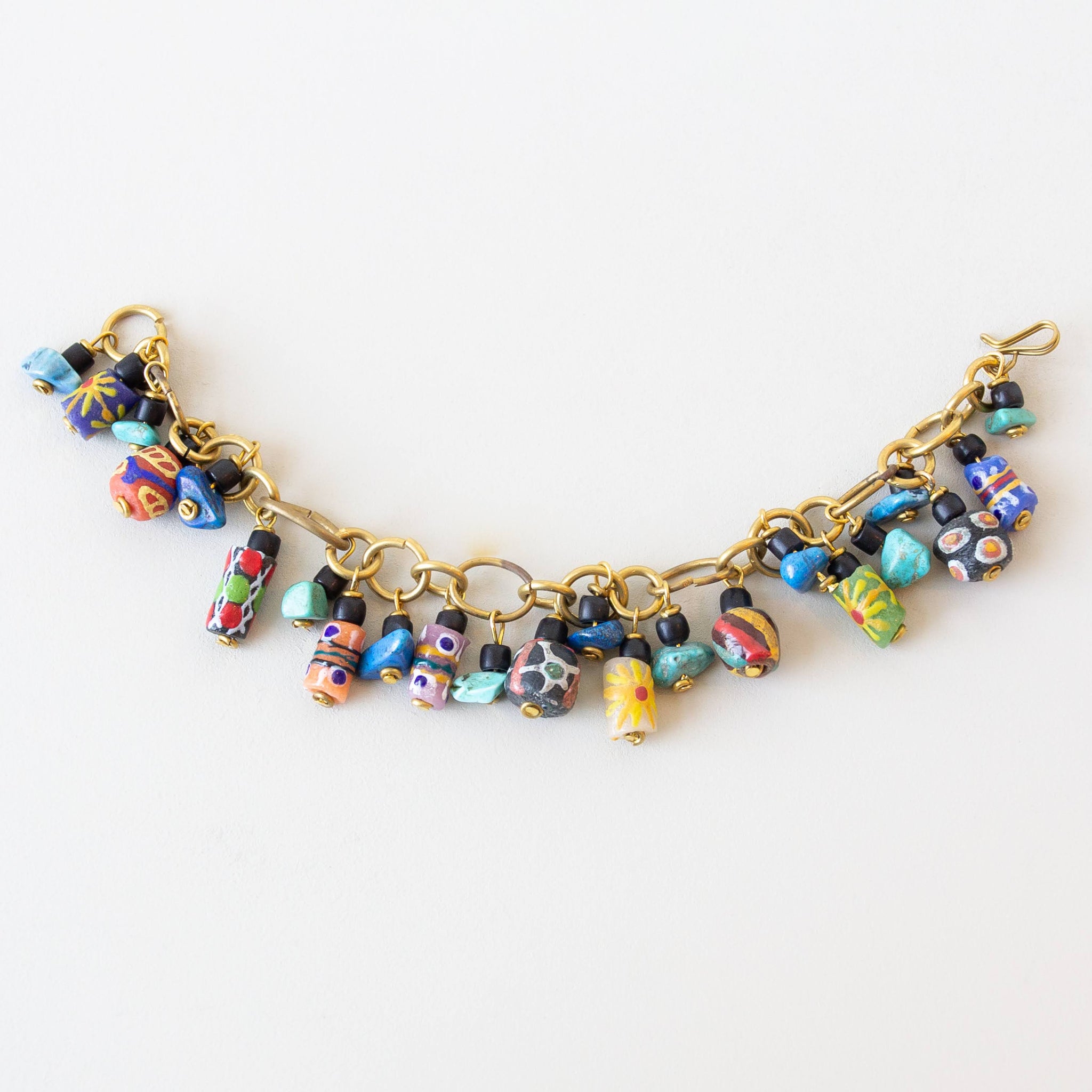 Colorful beaded bracelet with gold chain on a white background